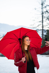 young girl with a red umbrella in the winter