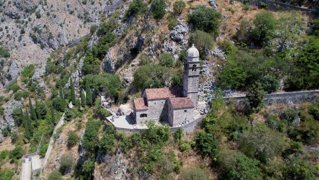 Aerial Partial Orbit Around Small Stone Roman Catholic Medieval Mountainside Church of Our Lady of Remedy Ladder of Kotor Montenegro Summer Day Drone 4k