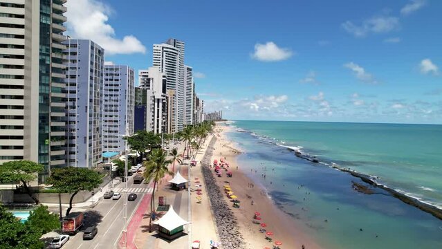 Aerial Slow Rise Above Vibrant Summer Beach and Street Shoreline of Tropical Coastal City Recife Brazil Turquoise Ocean Summer Day Drone 4k