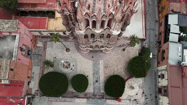 Top Down Pass Over Top of Colorful Historic Cathedral Church Tower Parroquia de San Miguel Arc&aacute;ngel San Miguel de Allende Guanajuato Mexico Drone 4k