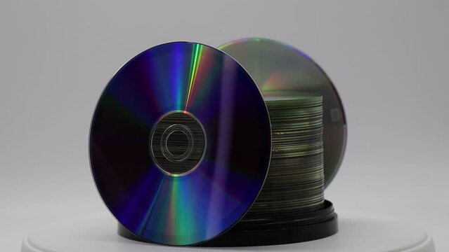 A stack of DVDs on spool rotating on white background. Retro style technology 
