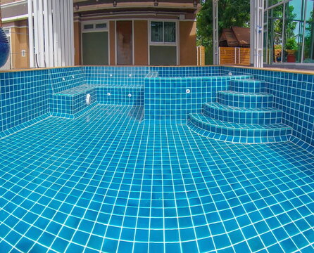 Construction of swimming pool spa chair.Tile installation at the corner of the pool.Construction Pool.	