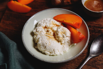 Homemade ricotta cheese or cheese curd served with fresh persimmon and honey and croissante on...