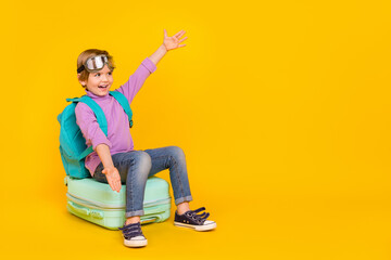 Photo of funny good mood casual wear boy kid prepare to travel go on adventure isolated on yellow color background