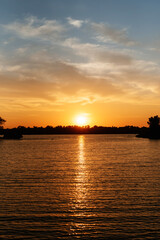 Fototapeta premium orange sunset on the river with silhouettes