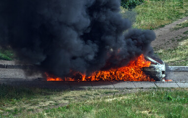 Extinguishing a burning car.Black smoke and giant flames.