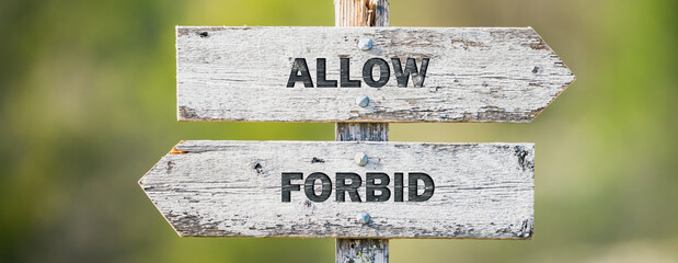 opposite signs on wooden signpost with the text quote allow forbid engraved. Web banner format.