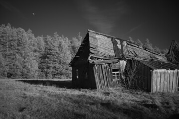 Old abandoned damaged wooden house in black and white