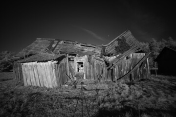 Old abandoned damaged wooden house in black and white