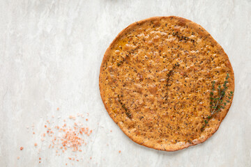 Baked focaccia round flat bread. Homemade pastry food with thyme herbs and salt.