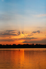 Naklejka premium orange sunset on the river with silhouettes