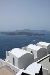 View of  luxury villas with balconies  and a ferry boat next to the volcano of Santorini 