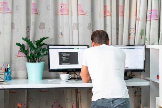 Man Working On Computer At Standing Desk At Home Office