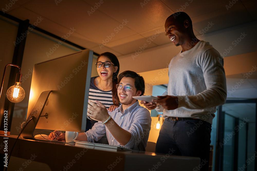 Poster Cracking codes is what makes them happy. Shot of computer programmers working together late in the office.