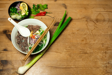 Pho Bo - Vietnamese fresh rice noodle soup with beef, herbs and chili. Vietnam's national dish.
