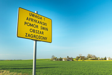 Yellow sign with the inscription in Polish, Attention! African swine fever endangered area