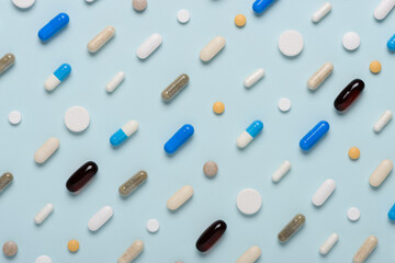 Pills pattern on blue background.  Assorted medicine drugs texture flat lay.