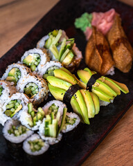 Japanese sushi food. Vegan sushi with avocado and cucumber. Top view of sushi. Rainbow sushi roll, uramaki, hosomaki, tamagoyaki and nigiri.