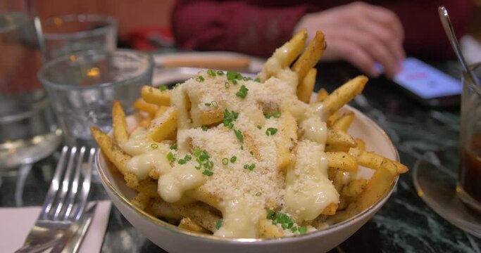 Bowl Of Delicious Parmesan Truffle Fries With Cheddar Cheese Served On The Table For Snack. close up