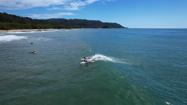 Two surfer are surfing in Santa Teresa in Costa Rica filmed with a drone