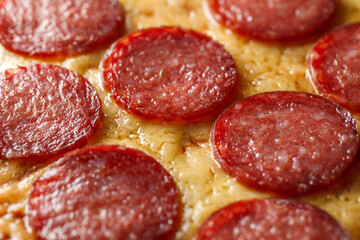 Pepperoni pizza with round pieces of sausage close-up, selective focus.