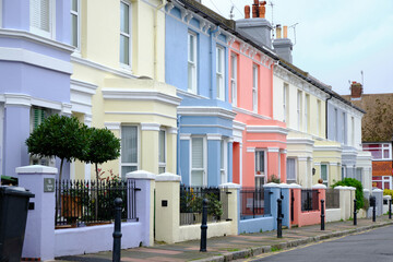 Eastbourne, United Kingdom - 26 October 2021: English street with colourful vintage terraced houses. Diminishing perspective.