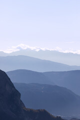 Fototapeta na wymiar Mountain ranges of Val Gardena covered with morning haze in Seiser Alm, Italy (Vertical photo)