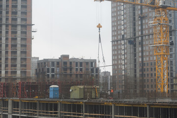 Large residential tower under construction with yellow large cranes