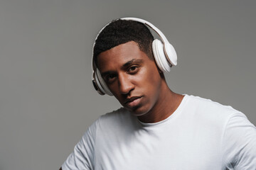 Young black man listening music with wireless headphones