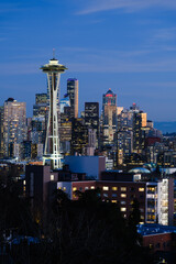 Seattle - February 11, 2022;  Seattle city skyline lights up at dusk behind the Space Needle under...