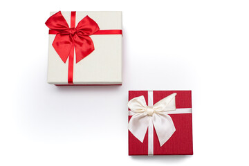 Two white and red gift boxes with ribbons and bows on a white background. Gifts for birthday or traditional holidays. Two gift boxes arranged diagonally with free space for text