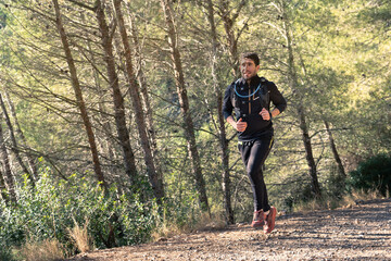 Fototapeta premium Man trail running in the mountains on a path.