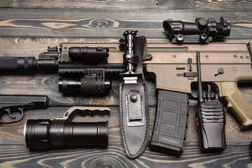 Airsoft equipment on the wooden flat lay table background.