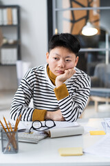 Asian bored businesswoman tired of her work sitting at her workplace with computer and documents at office