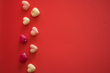 flat lay heart shape of macarons on red background