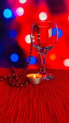 Wine glasses in a nighttime candle light dinner, fine dinning setting for Saint Valentine’s day. Red tone bokeh light blur background
