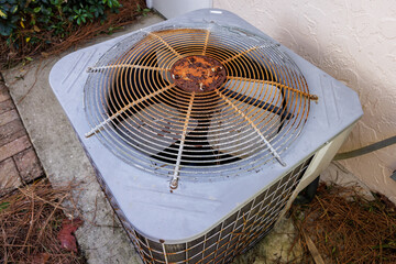 HVAC air conditioner in need of repair. Top view of old rusty AC unit fan.