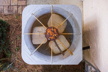 Rusty HVAC air conditioner in need of repair. Top down view of old AC unit fan.