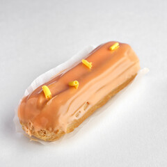 Traditional French dessert. eclair with custard and glaze on a white background.