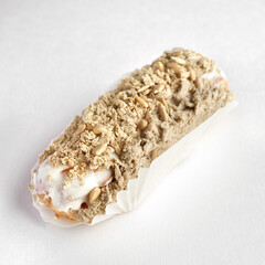 Traditional French dessert. eclair with custard and glaze with halva on a white background.