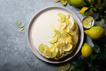 cheesecake citron speculoos fait maison sur table avec agrumes et feuilles vertes