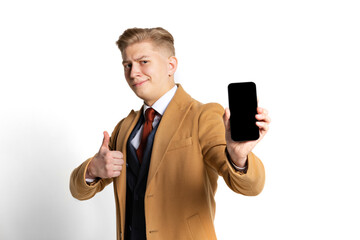 Portrait of young businessman, student, elegant man wearing suit and beige coat using phone isolated on white studio background.