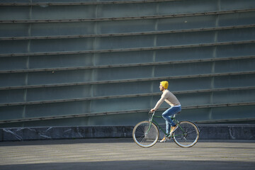 Hispanic man riding an urban bicycle in the sun.
