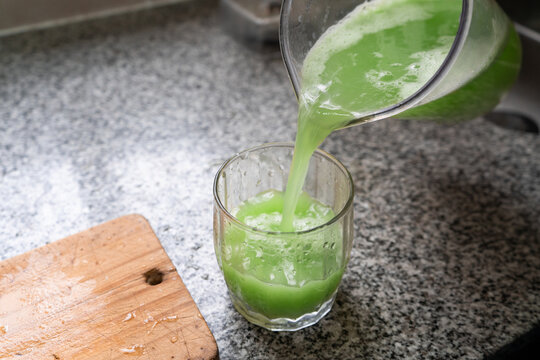Pouring healthy green juice in glass