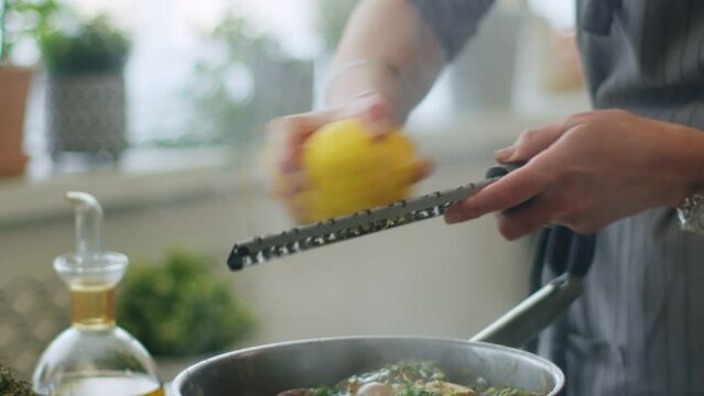 Woman adding lemon zest to stewing ossobuco