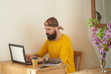 Focused hipster working on laptop