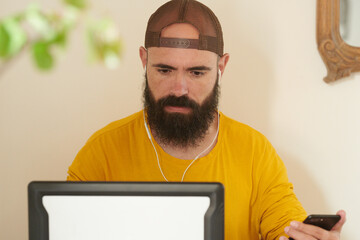 Bearded man browsing laptop