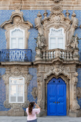Young girl photographing the Raio´s Palace in the historic centre of a European city