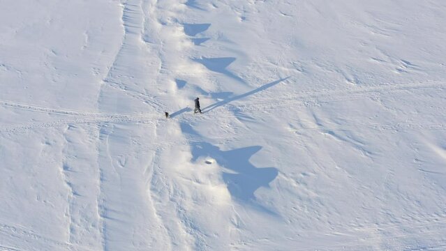 fishermen goes on ice covered water after fishing , aerial view