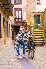 Obraz premium Latin woman doing bicycle tourism in the city. Ecological tourism lifestyle